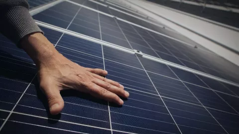 mano en un panel solar