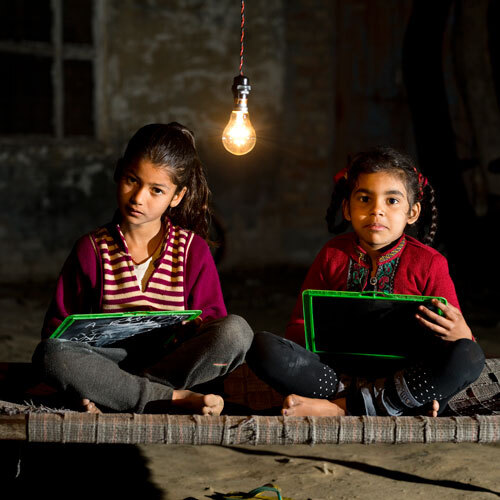 crianças a estudar com uma lâmpada