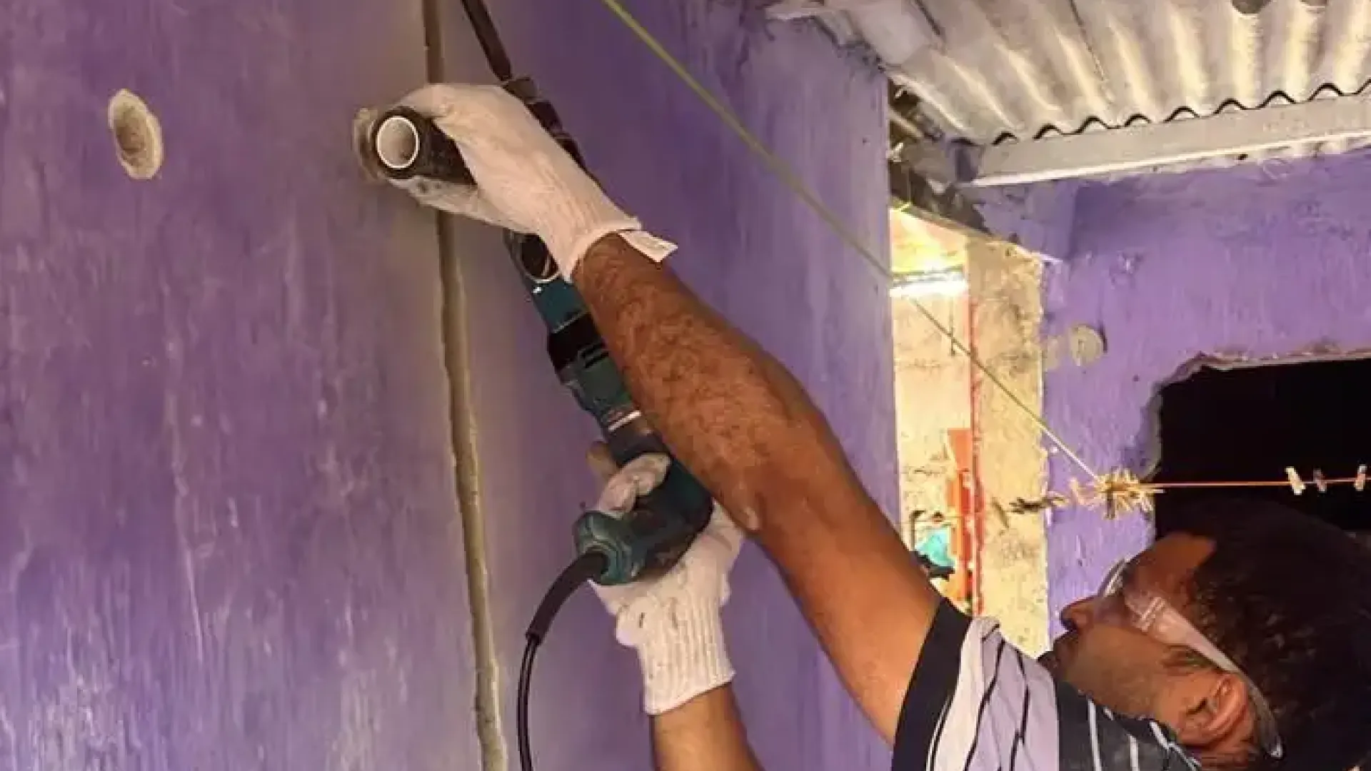 Rapaz fazendo obra numa parede