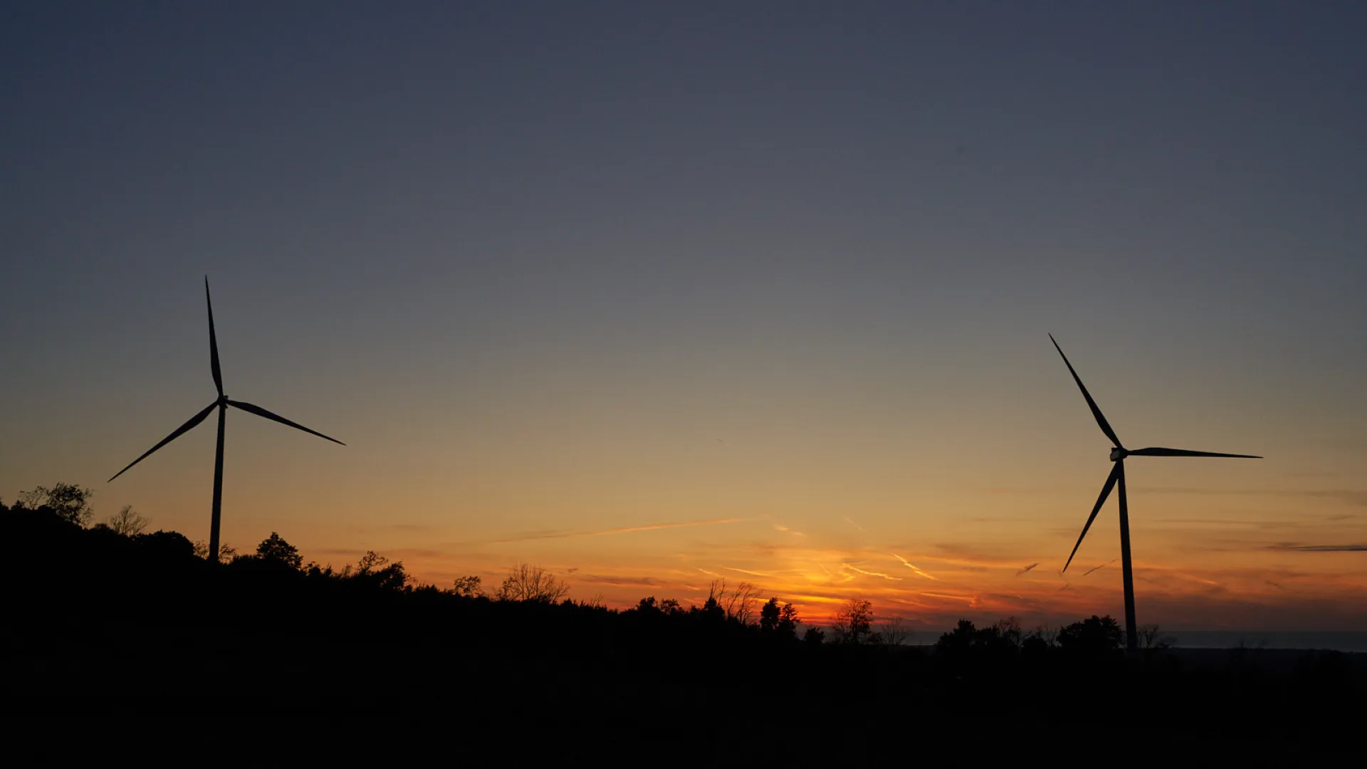 Image of two wind turbines at sunset