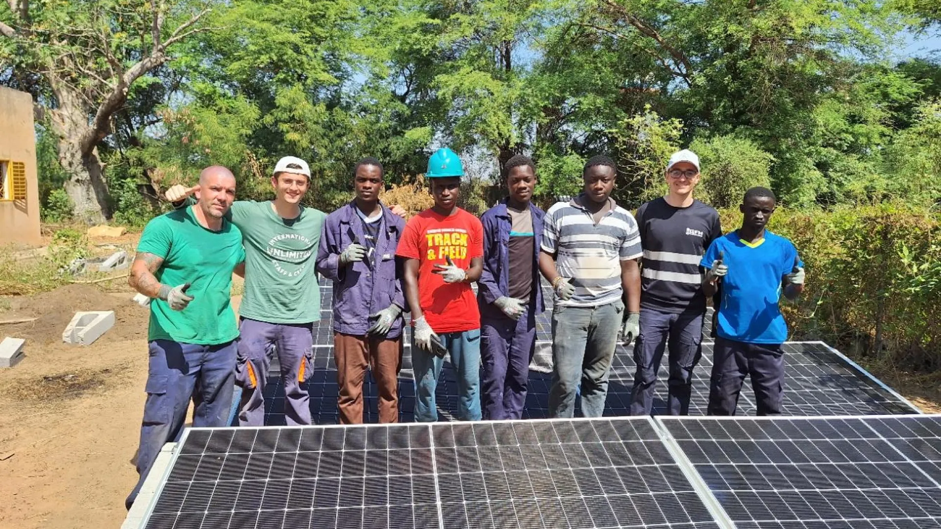 kids standing next to a solar panel