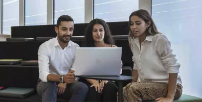 three employees meeting around a computer