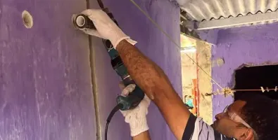 Rapaz fazendo obra numa parede