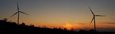 Image of two wind turbines at sunset