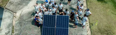 kids standing next to a solar panel