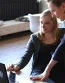 two people looking at a laptop screen.